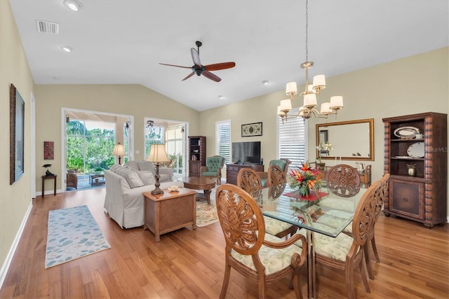 dining area featuring ceiling fan with notable chandelier, light hardwood / wood-style flooring, and lofted ceiling