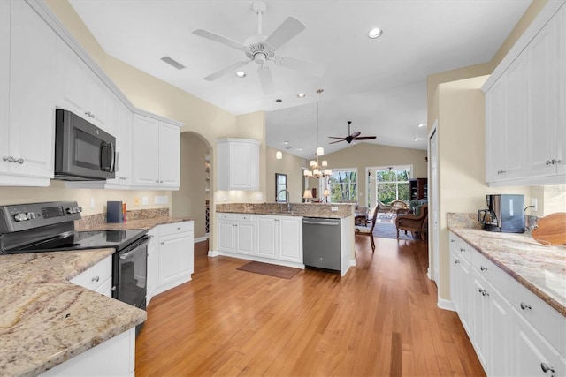 kitchen featuring light hardwood / wood-style flooring, pendant lighting, vaulted ceiling, white cabinets, and appliances with stainless steel finishes