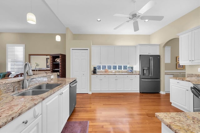 kitchen with white cabinetry, sink, light hardwood / wood-style flooring, decorative light fixtures, and appliances with stainless steel finishes