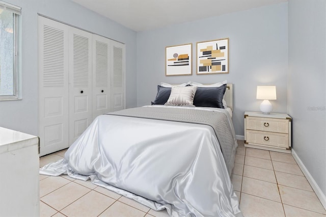 bedroom with light tile patterned floors and a closet