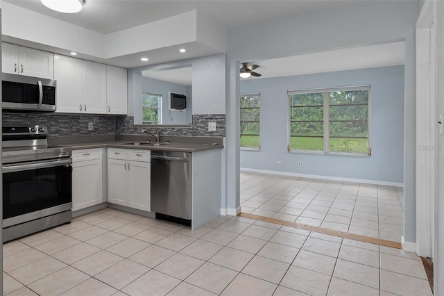 kitchen featuring white cabinets, backsplash, stainless steel appliances, and sink