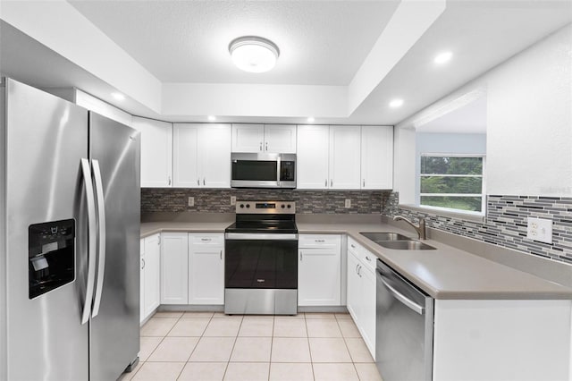 kitchen featuring sink, white cabinets, stainless steel appliances, and a textured ceiling