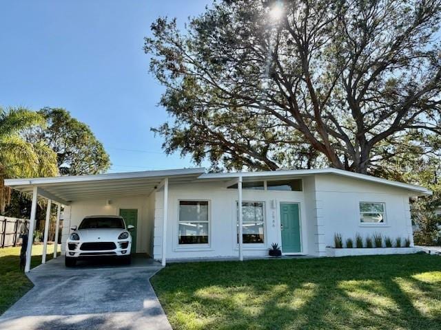 ranch-style home featuring a front yard and a carport