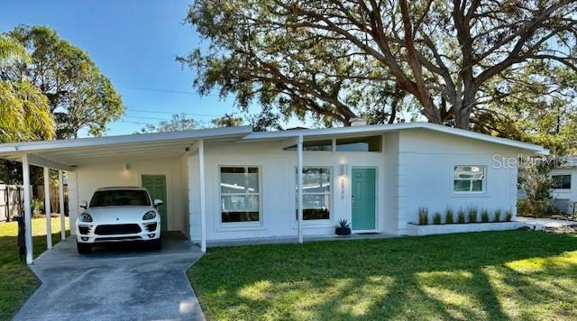 view of front of home with a front lawn and a carport