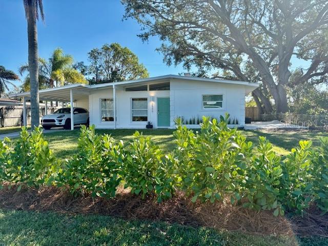 view of front of house featuring a carport and a front yard