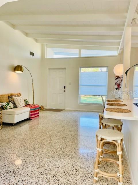 foyer entrance featuring beam ceiling