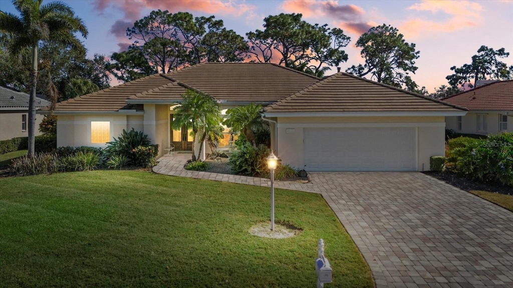 view of front facade featuring a garage and a lawn