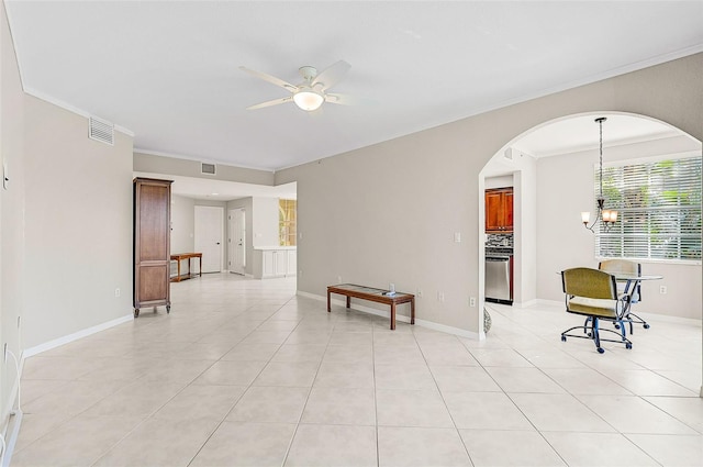 tiled empty room with ceiling fan with notable chandelier and ornamental molding