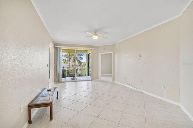 tiled empty room featuring ceiling fan and crown molding