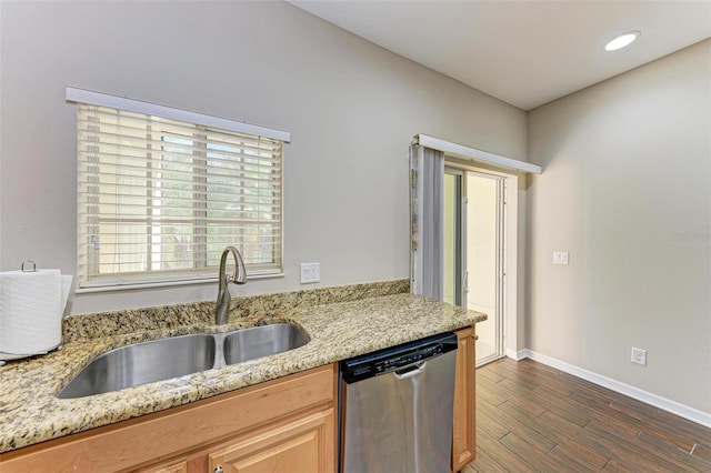 kitchen with light stone countertops, dishwasher, and sink