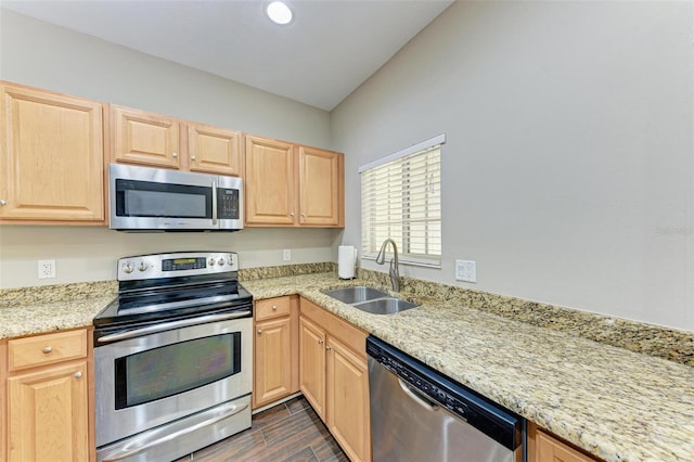 kitchen with light stone counters, sink, light brown cabinets, and appliances with stainless steel finishes