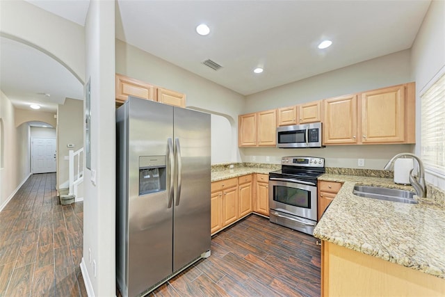 kitchen featuring light brown cabinets, light stone countertops, sink, and appliances with stainless steel finishes