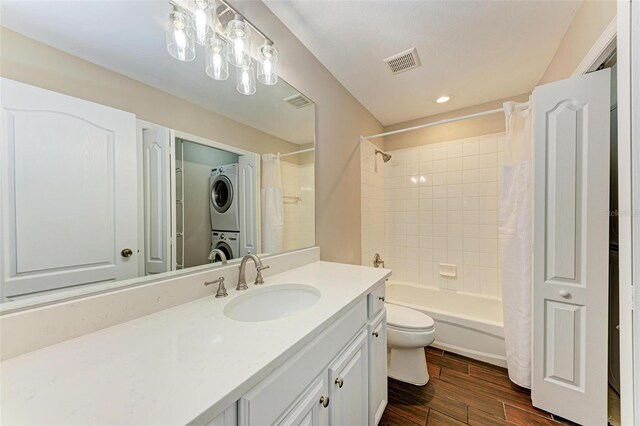 full bathroom featuring shower / bath combo, toilet, stacked washing maching and dryer, and vanity