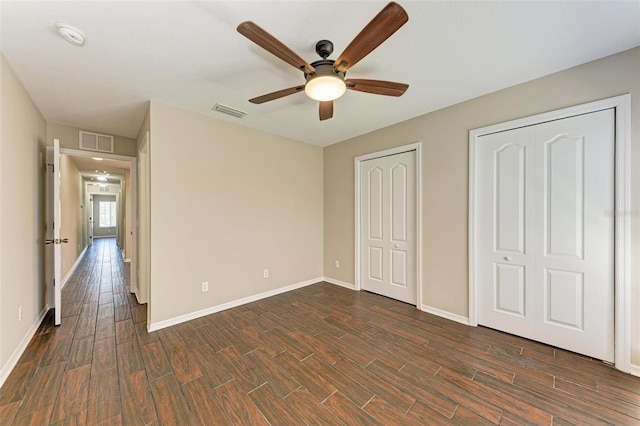 unfurnished bedroom with two closets and ceiling fan