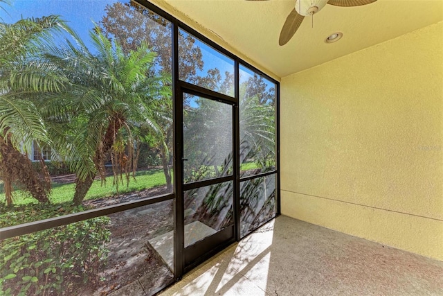 unfurnished sunroom featuring ceiling fan