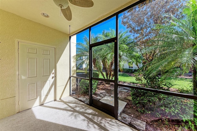 unfurnished sunroom featuring ceiling fan