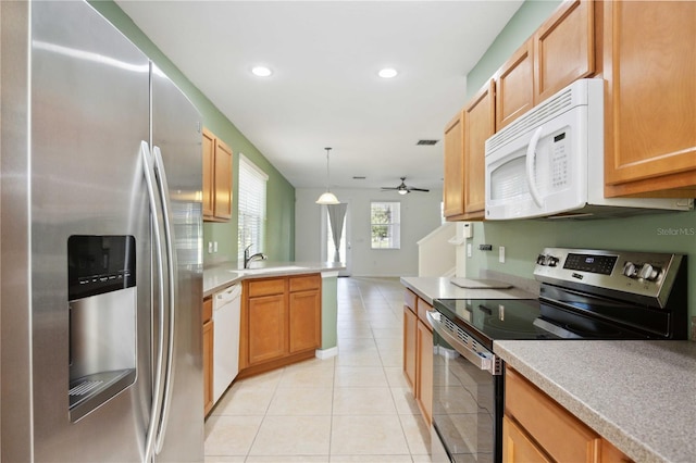 kitchen with pendant lighting, sink, ceiling fan, light tile patterned floors, and stainless steel appliances