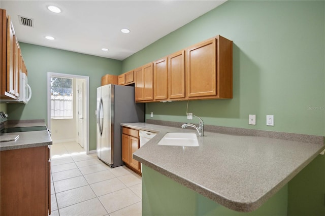 kitchen with kitchen peninsula, white appliances, light tile patterned flooring, and sink