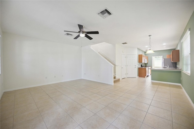 unfurnished living room featuring ceiling fan and light tile patterned floors