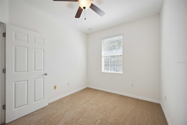 carpeted spare room featuring ceiling fan