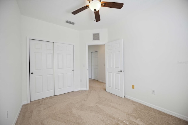 unfurnished bedroom featuring ceiling fan, light carpet, and a closet