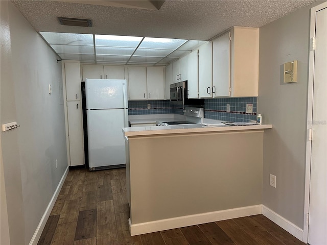 kitchen with stove, dark hardwood / wood-style flooring, white fridge, and white cabinetry