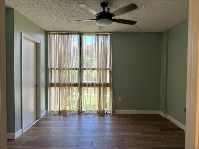 spare room with ceiling fan, a textured ceiling, and dark wood-type flooring