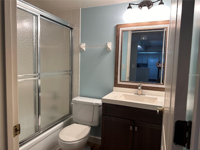 full bathroom with combined bath / shower with glass door, vanity, and toilet