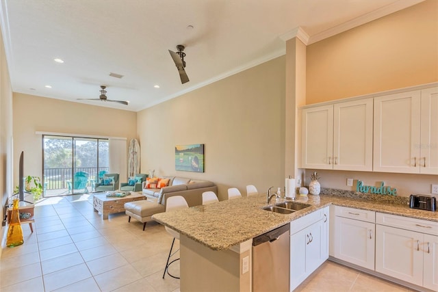 kitchen featuring a kitchen breakfast bar, stainless steel dishwasher, kitchen peninsula, and white cabinets