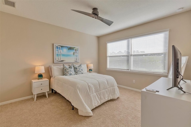 carpeted bedroom with multiple windows and ceiling fan