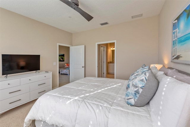 bedroom with ceiling fan, carpet floors, and ensuite bath