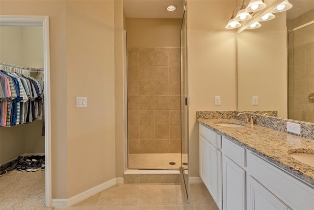 bathroom featuring vanity, a shower with shower door, and tile patterned flooring