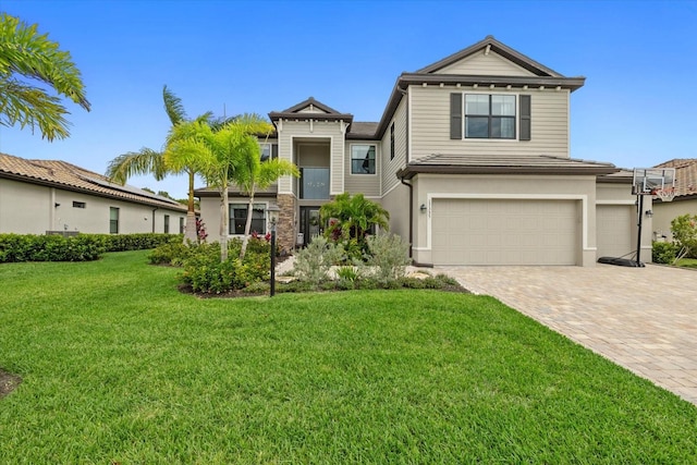 view of front of house featuring a garage, a front lawn, and decorative driveway