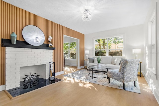 living room with a fireplace, wood-type flooring, and a notable chandelier