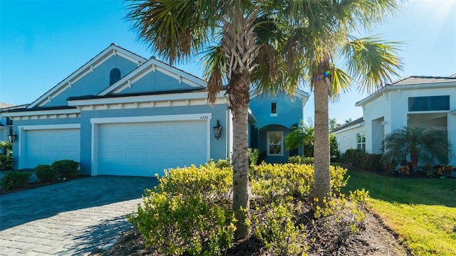 4326 Tamarind Pl, Bradenton, FL 34203 - view of front of property with stucco siding, decorative driveway, an attached garage, and a front lawn