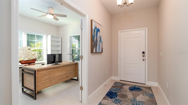 entrance foyer with light tile patterned floors and ceiling fan with notable chandelier