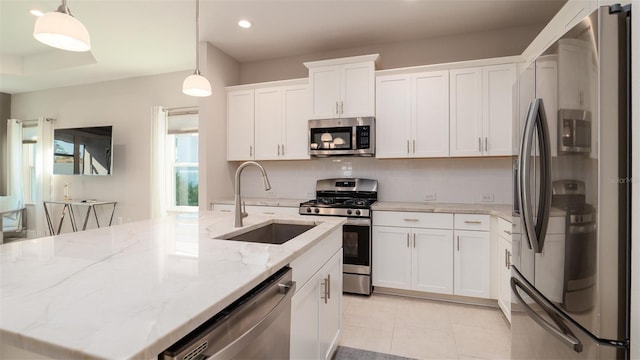 4326 Tamarind Pl, Bradenton, FL 34203 - kitchen featuring appliances with stainless steel finishes, a sink, a center island with sink, white cabinets, and hanging light fixtures