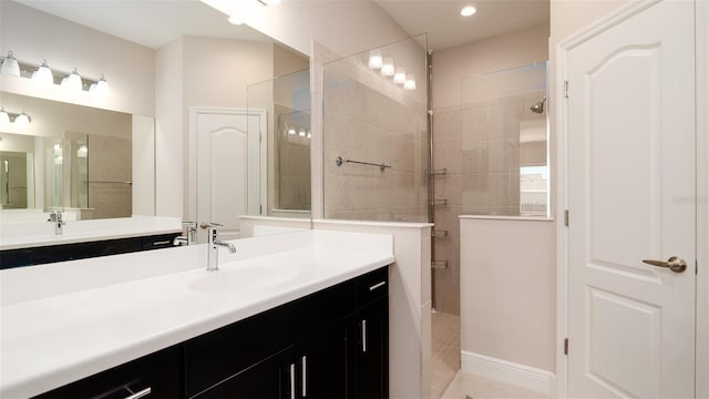 bathroom with tiled shower and vanity