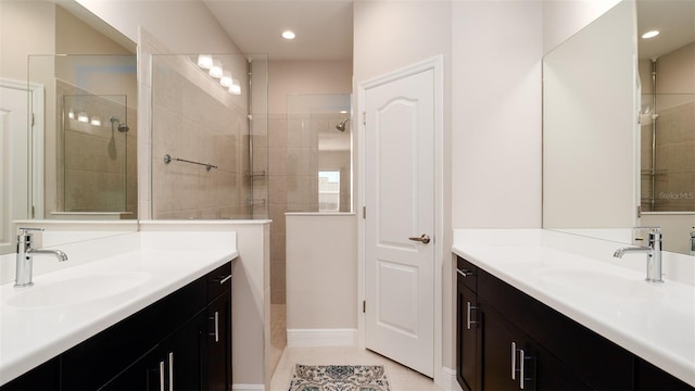 bathroom featuring a tile shower, tile patterned flooring, and vanity