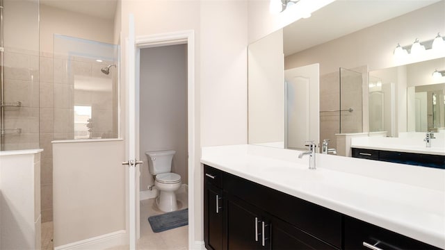 bathroom featuring tile patterned flooring, toilet, a tile shower, and vanity