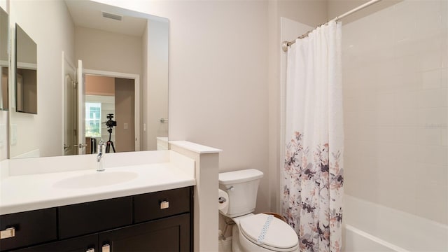 full bathroom with shower / tub combo with curtain, vanity, and toilet