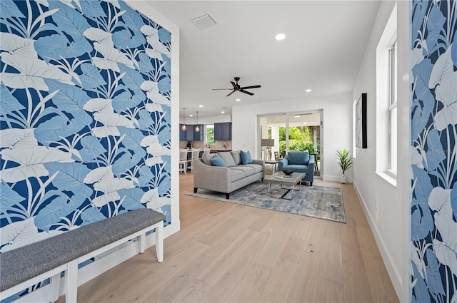 living room with light hardwood / wood-style flooring and ceiling fan