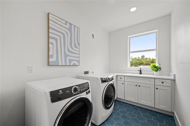 washroom with washer and clothes dryer, cabinets, sink, and dark tile patterned flooring