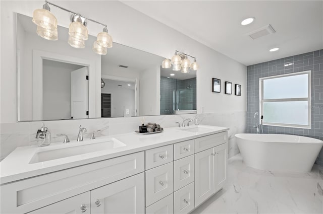 bathroom with vanity, tile walls, and shower with separate bathtub