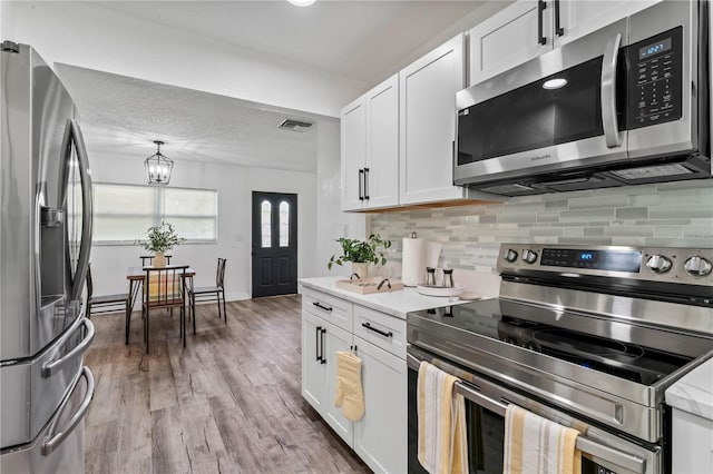 kitchen featuring white cabinetry, light hardwood / wood-style flooring, and stainless steel appliances