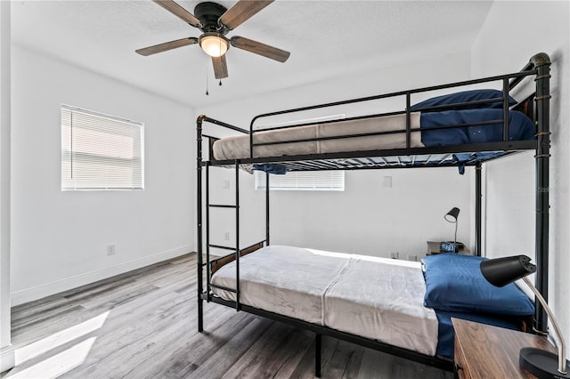 bedroom with hardwood / wood-style floors, a textured ceiling, and ceiling fan