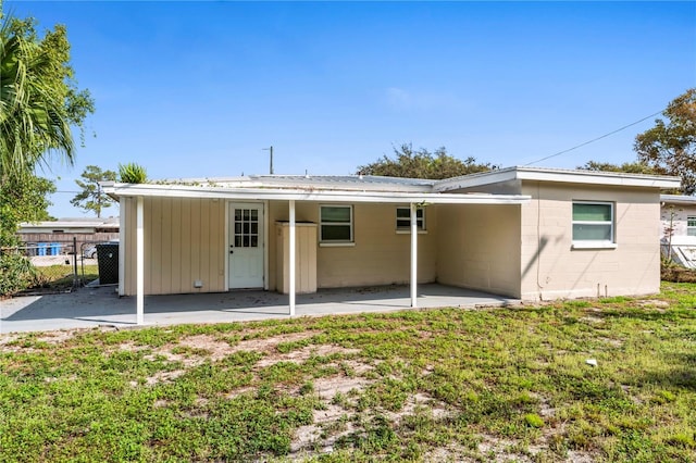 back of property with a patio and a lawn