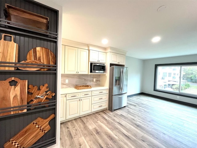 kitchen featuring decorative backsplash, stainless steel appliances, and light hardwood / wood-style flooring