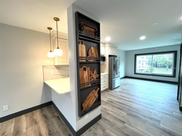 kitchen featuring light wood-type flooring, stainless steel appliances, and white cabinetry