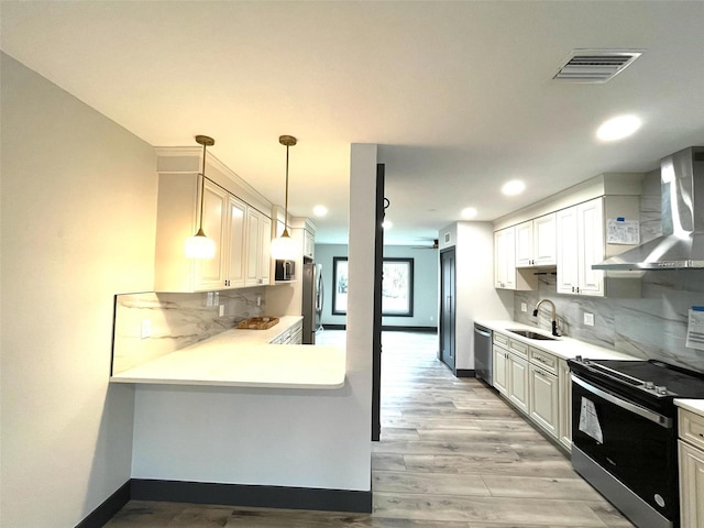 kitchen with wall chimney exhaust hood, ceiling fan, white cabinetry, and stainless steel appliances